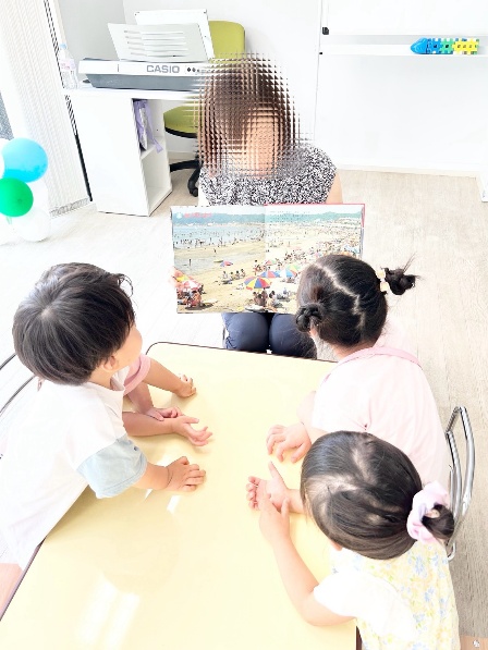 先生の読み聞かせを聞く子どもたち